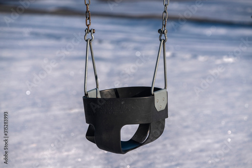 Swing seat in a kids playground in winter © Jason