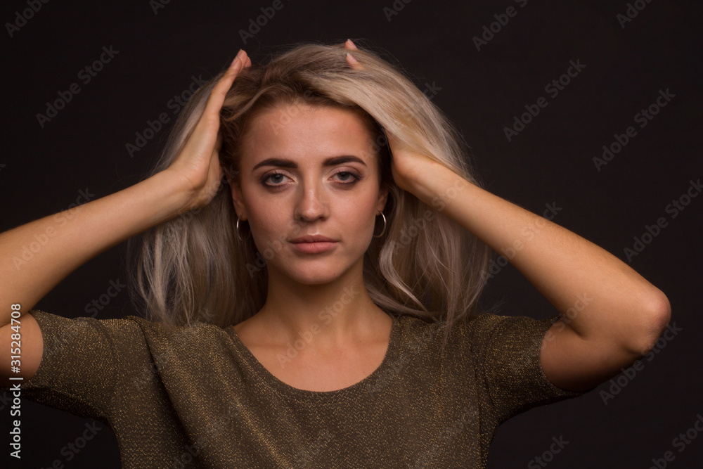 Studio portrait of a young beautiful girl on a black background Studio portrait of a young beautiful girl on a black background