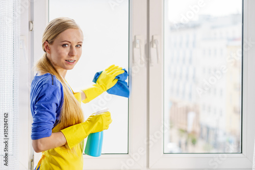Woman cleaning window at home