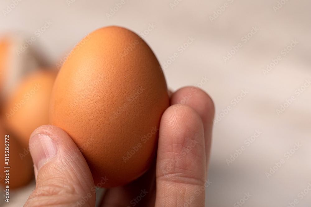 men's hand with egg on blur background men's hand with egg on blur background