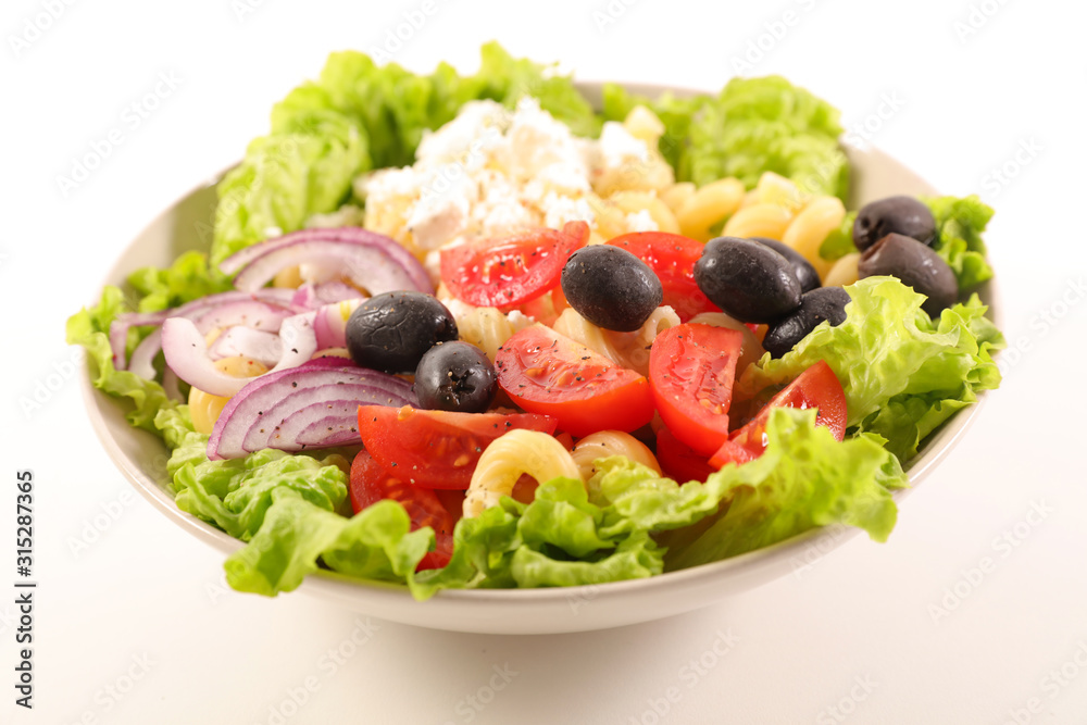 mixed vegetable salad with tomato, olive, onio, feta cheese and pasta