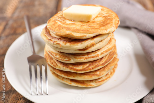 pile of pancake with butter on wood background