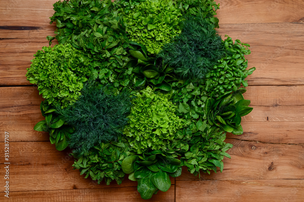 Fresh green lettuce salad mix on light wooden background with copy space Fresh green lettuce salad mix on light wooden background with copy space
