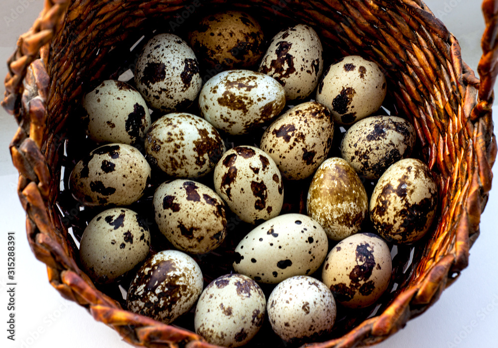 Obraz premium Quail eggs in a brown basket. View from above. Easter concept, proper nutrition.