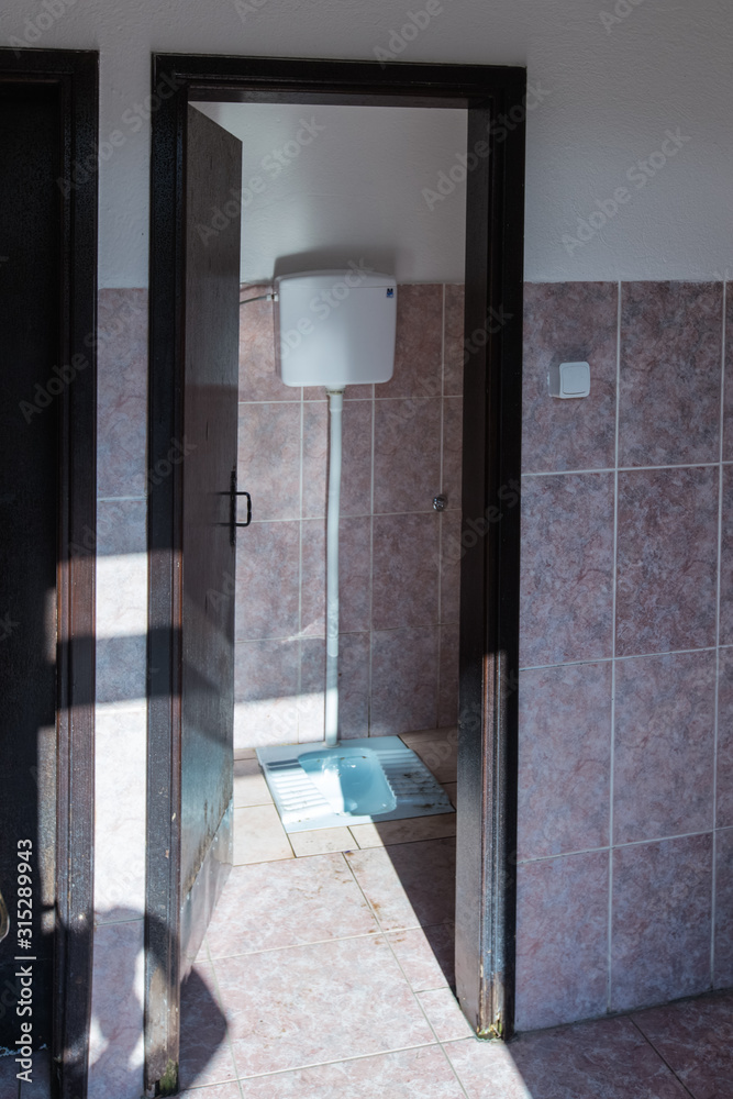 Old design of public toilet in monastery. Old style of toilet room. Squat toilet.