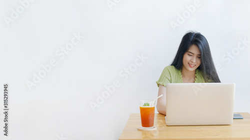 Young beautiful Asian woman working with laptop computer in coffee shop with copy space, Concept of female freelancer