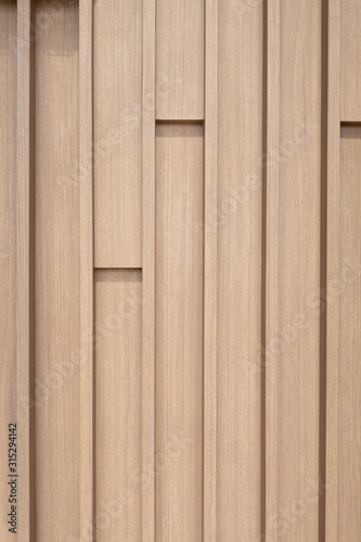 Close up vertically Texture of Large Brown decorative wooden battens wall pattern background.