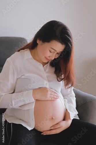 pregnant woman touching her belly with hands