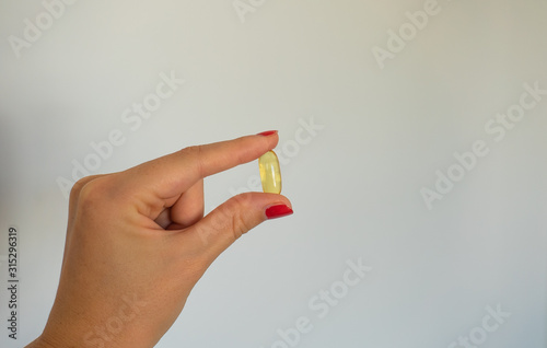 Yellow capsule in the hand