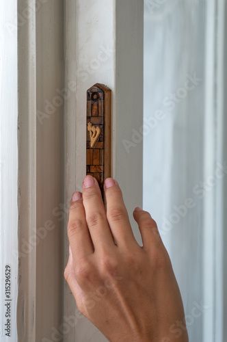 Girl touches wooden mezuzah in Tel Aviv photo