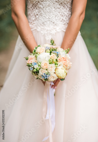 Beautiful wedding bouquet in hands of the bride