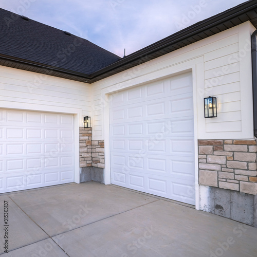 Square Two garage doors sharing a paved forecourt