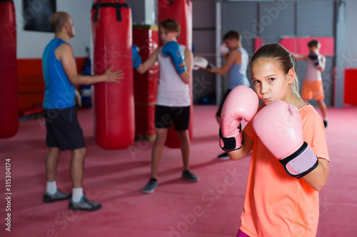 Portrait of young girl boxer in boxing hall