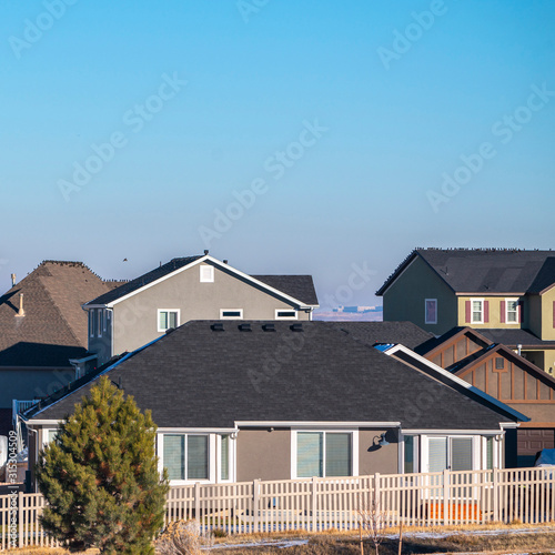 Square American houses with white fencing in winter © Jason