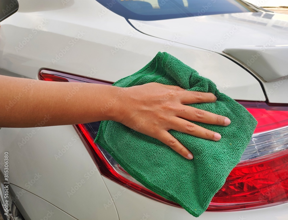 Hand of employees worker use clean Green cloth to wipe the car after washing in the car wash