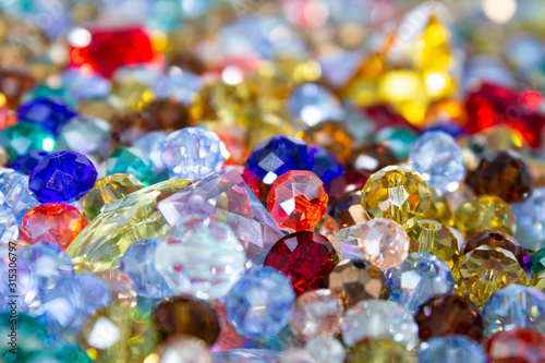 Heap of shining transpatent multicolored faceted glass beads close up.