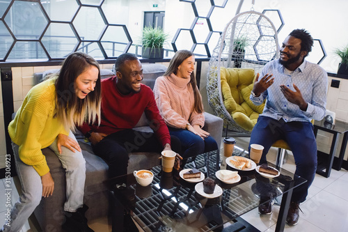 Group Of four Friends Meeting In Cafe.