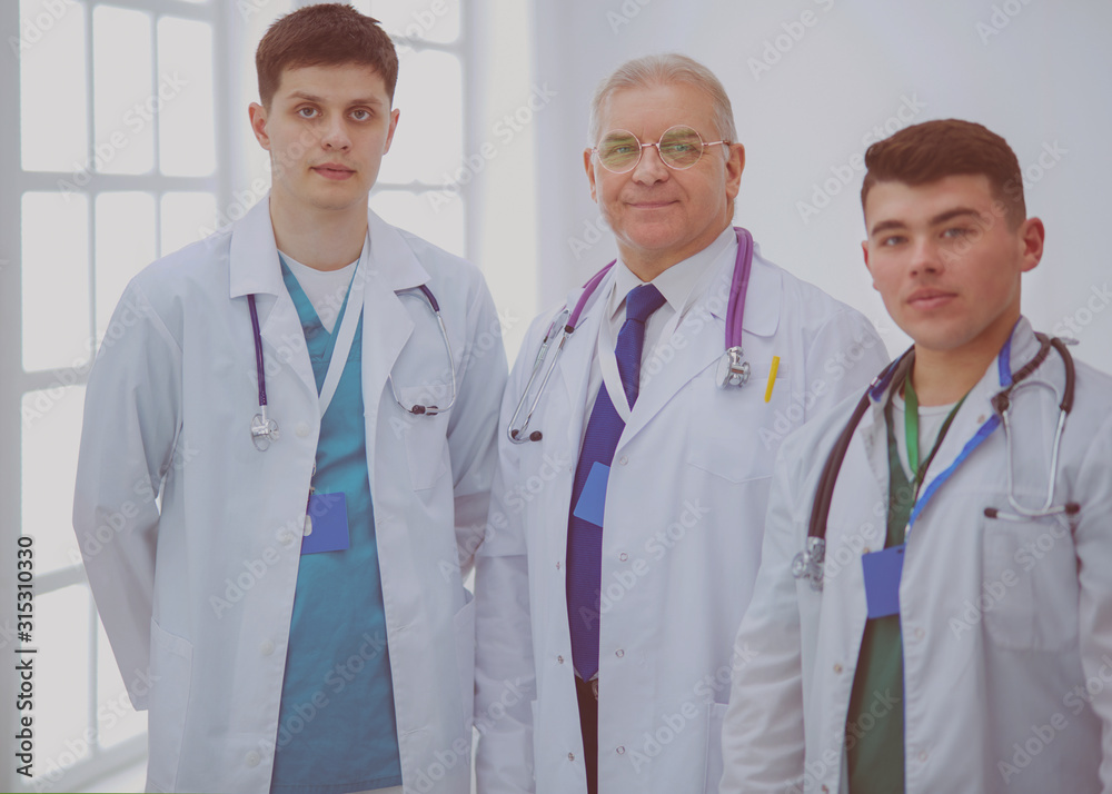 Successful medical team. Confident doctors team standing together and smiling Successful medical team. Confident doctors team standing together and smiling