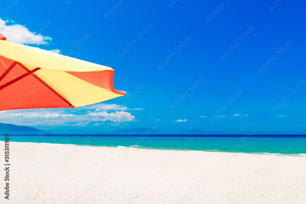 Empty white sand beach and parasol, blue sky Empty white sand beach and parasol, blue sky