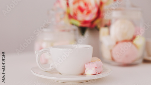 White cup with marshmallows. Romantic breakfast. Concept of holiday, birthday, Easter, International Womens Day. Feminine flat lay