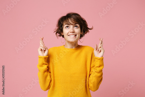 Murais de parede Pretty young brunette woman in yellow sweater posing isolated on pastel pink background