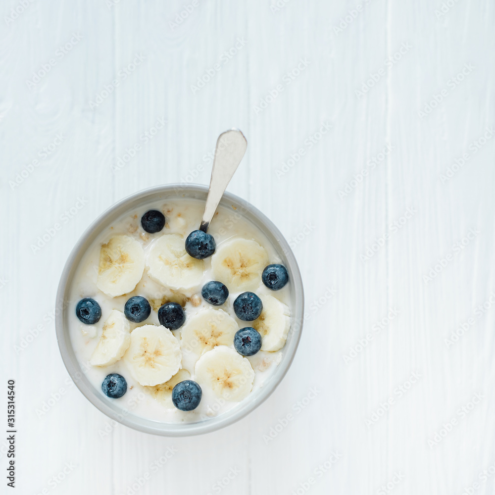 Healthy breakfast berry smoothie bowl topped with banana, granola, Blueberries and chia seeds with copy space Healthy breakfast berry smoothie bowl topped with banana, granola, Blueberries and chia seeds with copy space