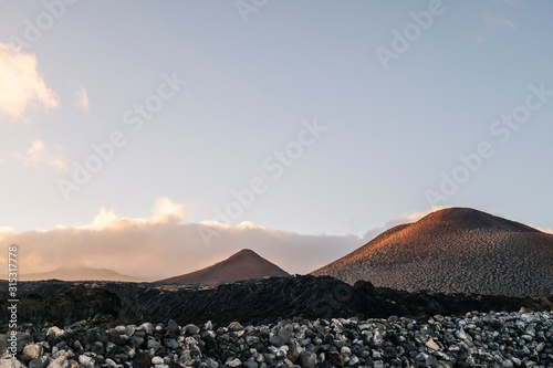Sunset landscape of mountains and volcanic rock soil