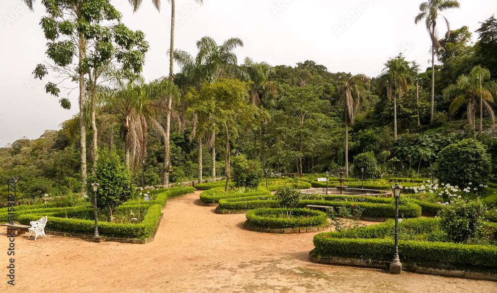 View to park with walkways, plant beds, trees and Atlantic forest background, Sanctuary Caraça, Minas Gerais, Brazil