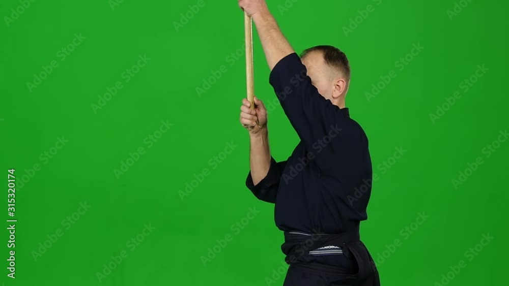 Masculine Kendo warrior practicing martial art with the bamboo bokken on green screen. Slow motion Masculine Kendo warrior practicing martial art with the bamboo bokken on green screen. Slow motion
