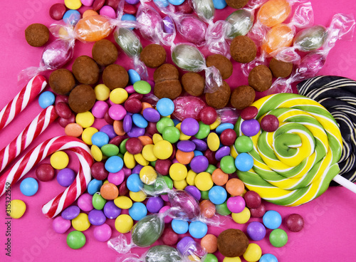 Colorful candies on a pink background stock images. Sweets on pink background. Mix of candies top view. Various colorful candies and sweets stock images. Candies and lollipops images