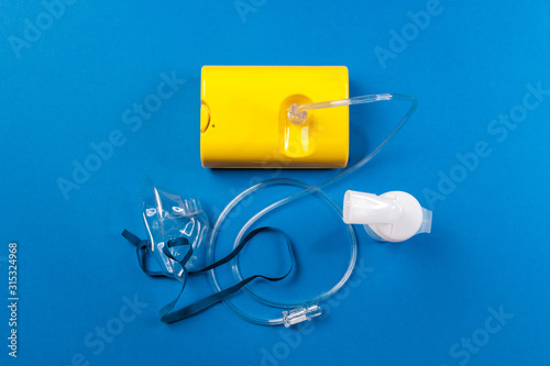 tube mask nebulizer and tubular transparent cable on blue background, disease cold, flu