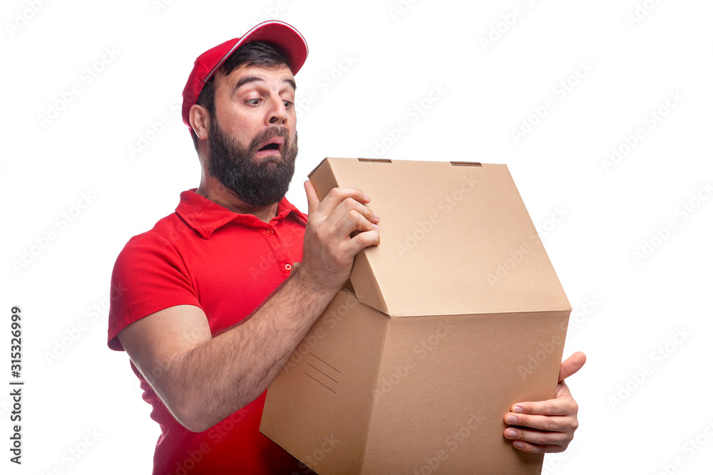man with a beard holds a box in a red T-shirt and cap on a white background in studio man with a beard holds a box in a red T-shirt and cap on a white background in studio