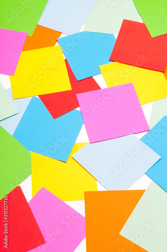 Colorful background of square paper memo sheets scattered on a white background