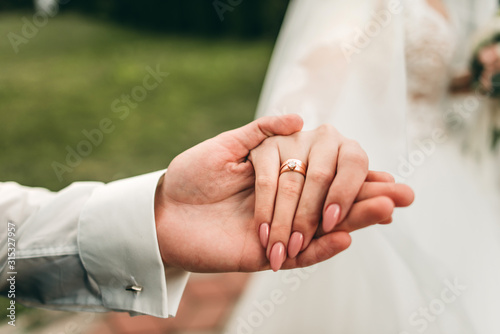 couple holding hands wedding rings