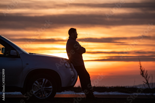 man standing near car on sunset. car travel concept