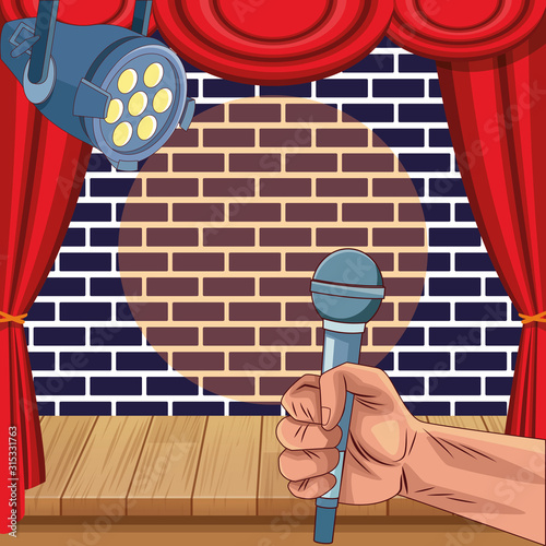 hand with microphone spotlight wall brick stage stand up comedy show