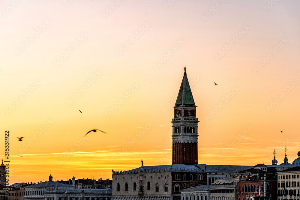 Colorful Venice skyline at sunset with St Mark's Campanile bell tower and the Doges Palace in Venice, Italy.