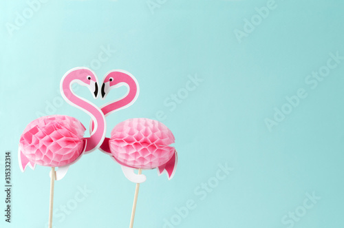 Fototapeta Naklejka Na Ścianę i Meble -  Decorative flamingos as a couple, shape of heart against blue background.Concept of love and relationships.Empty space for design