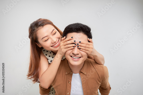 Positive cheerful woman close cover her spouse man eyes hug embrace piggy-back enjoy valentine day celebration isolated over white background