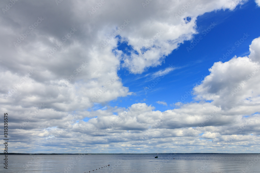 Heavenly landscape, blue sky with clouds over the lake.
