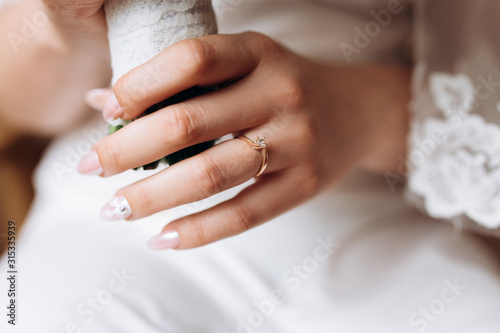 Bild auf Leinwand Bride's hand close up with a minimalistic engagement ring with a diamond