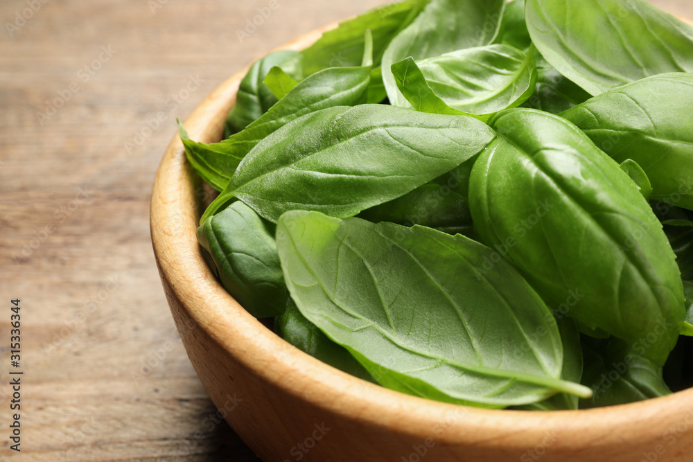 Fresh basil leaves on wooden table, closeup Fresh basil leaves on wooden table, closeup