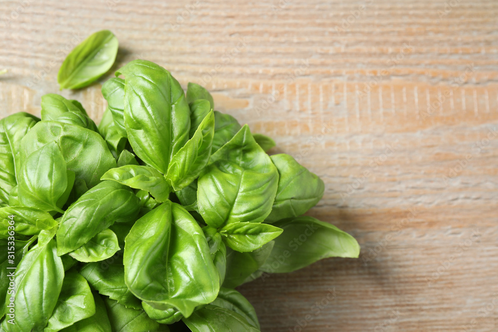Fresh basil on wooden table, top view. Space for text Fresh basil on wooden table, top view. Space for text