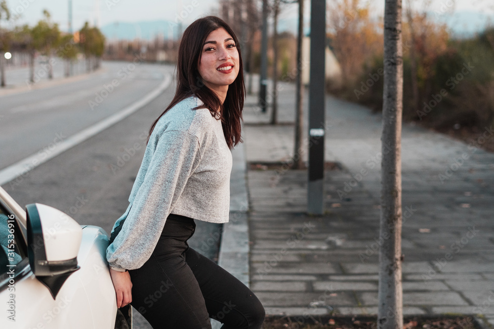 Chica joven con rasgos exóticos sentada en un coche Chica joven con rasgos exóticos sentada en un coche