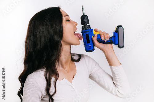 girl on a white background sexually licks a screwdriver