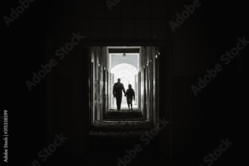 couple holding hands and walking into light together