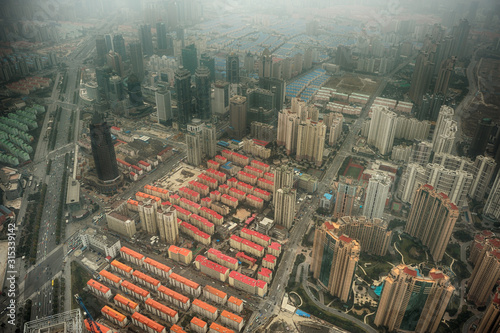 фотографія Bird view of modern buildings in Shanghai partially hidden by polluted air