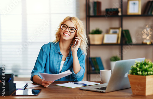 happy young   business woman at home office working on computer. © JenkoAtaman