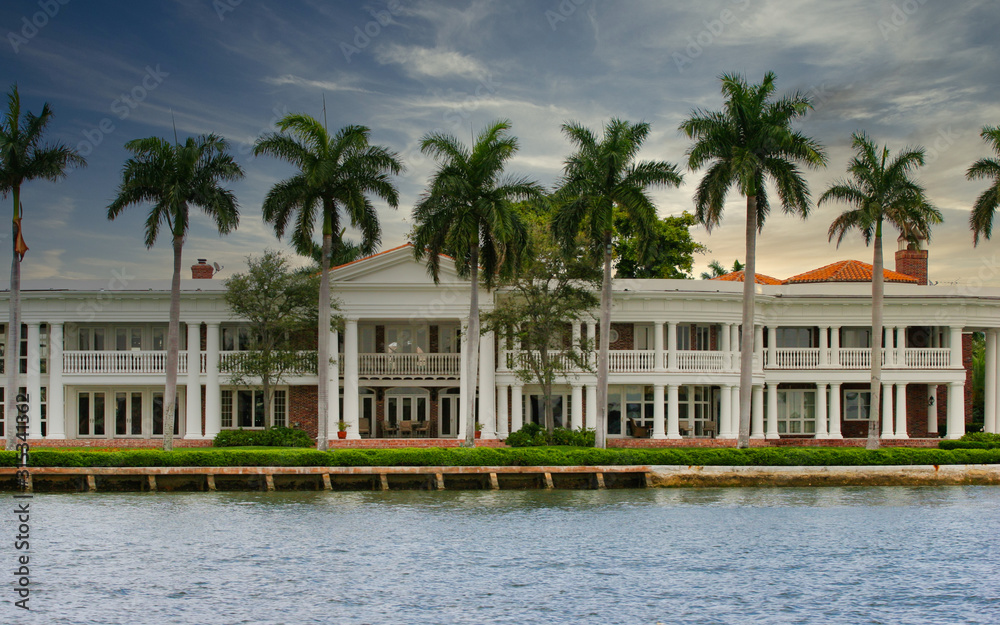 A coastal mansion lined with palm trees