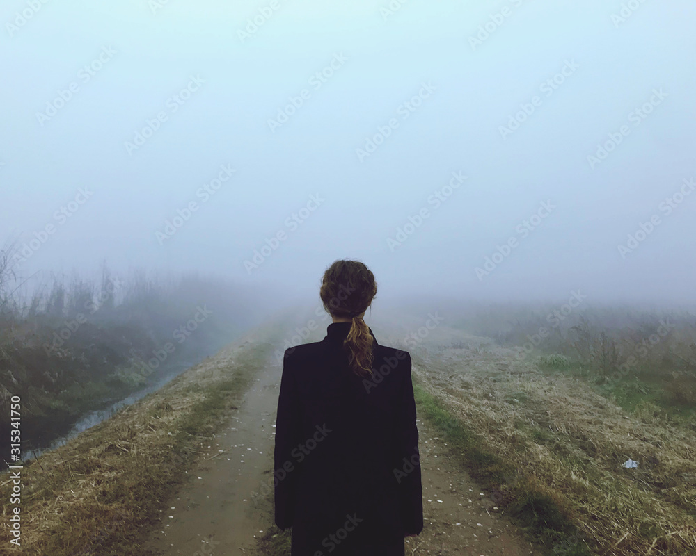 Una donna pensierosa nella nebbia nella ricerca di felicità Una donna pensierosa nella nebbia nella ricerca di felicità